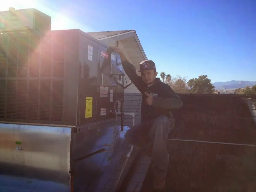 HVAC technician performing HVAC Inspection on a rooftop unit in Raisinville